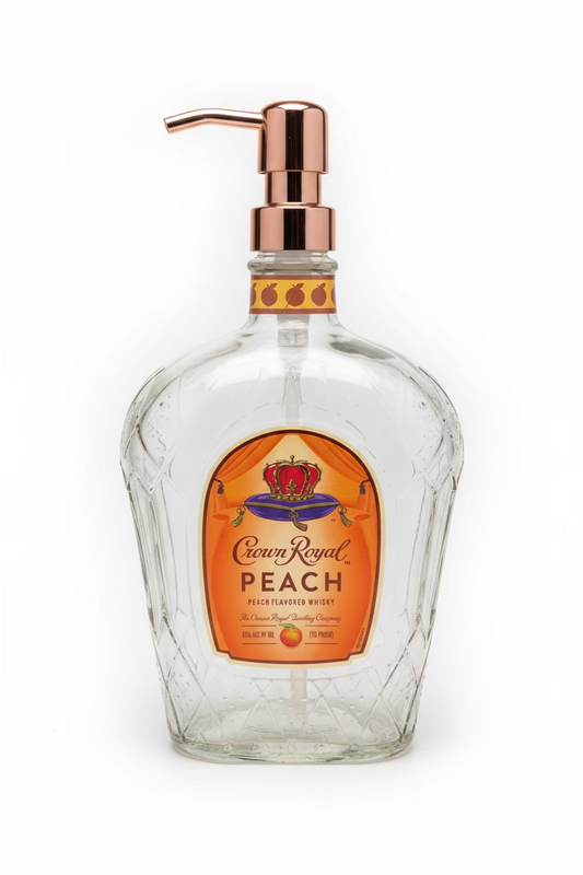 A clear glass soap dispenser with a peach-scented label and a metal pump.