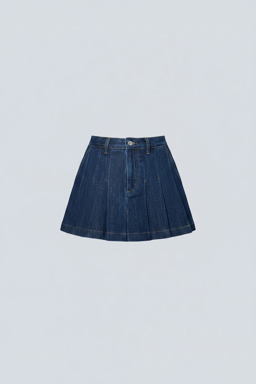 Person wearing a blue denim skirt and black cowboy boots against a light blue wall.