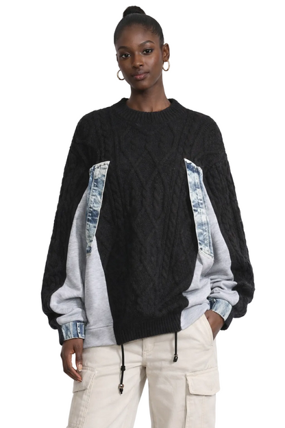 Women wearing a black and gray sweater with denim accents on a white background